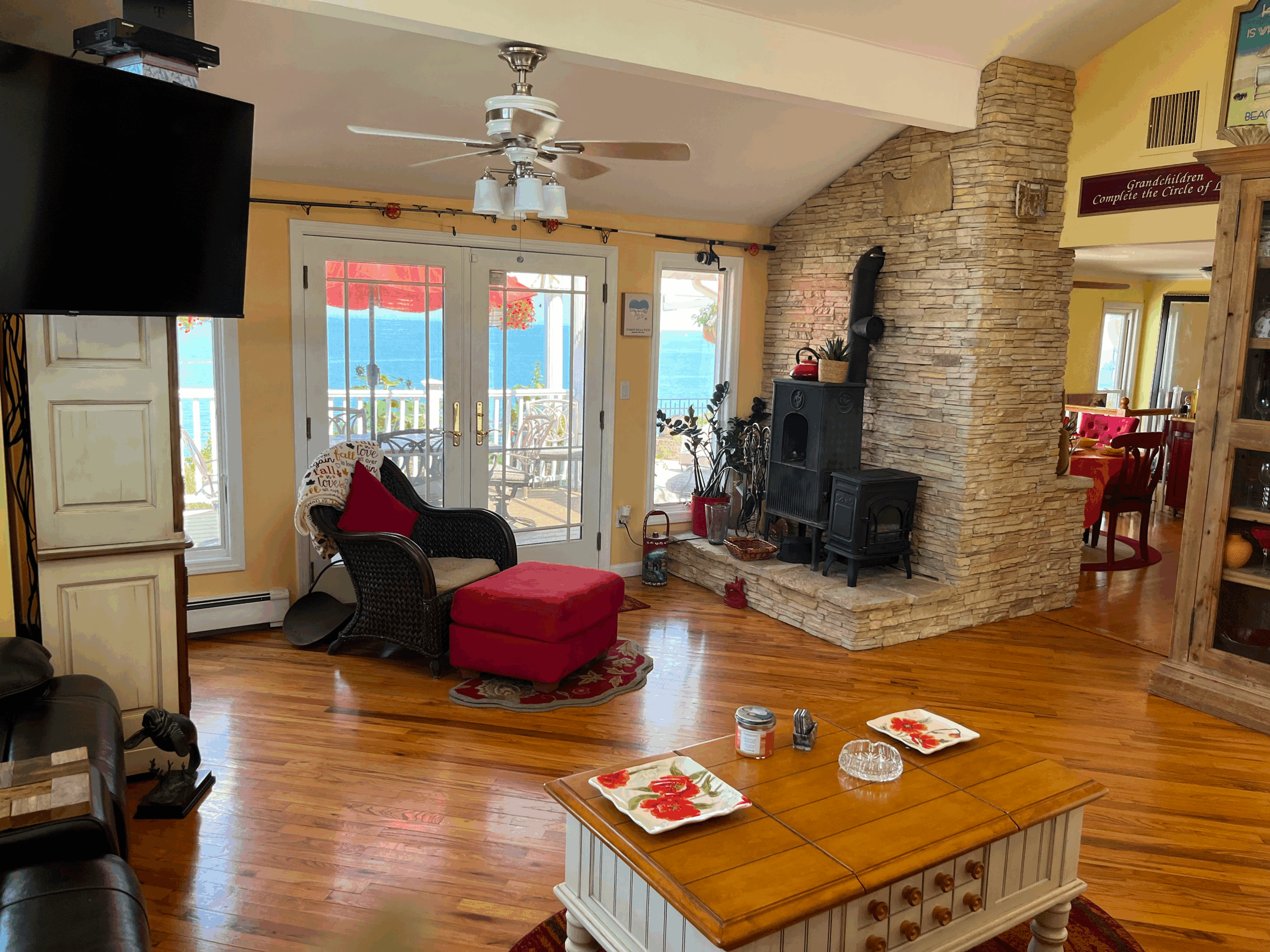 Cozy living room with red armchair and stone fireplace.