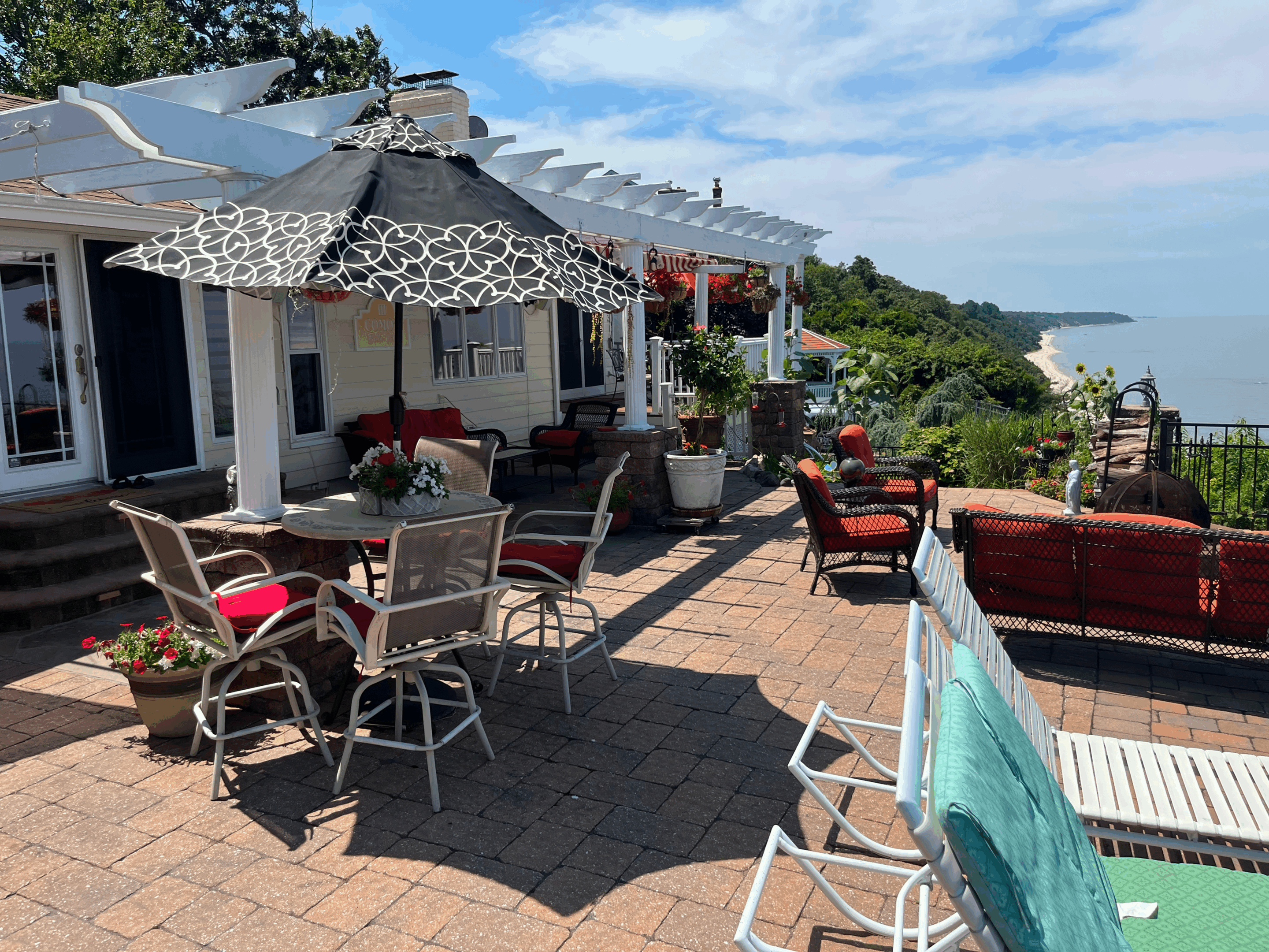 Outdoor patio with seating and umbrellas overlooking a scenic view.