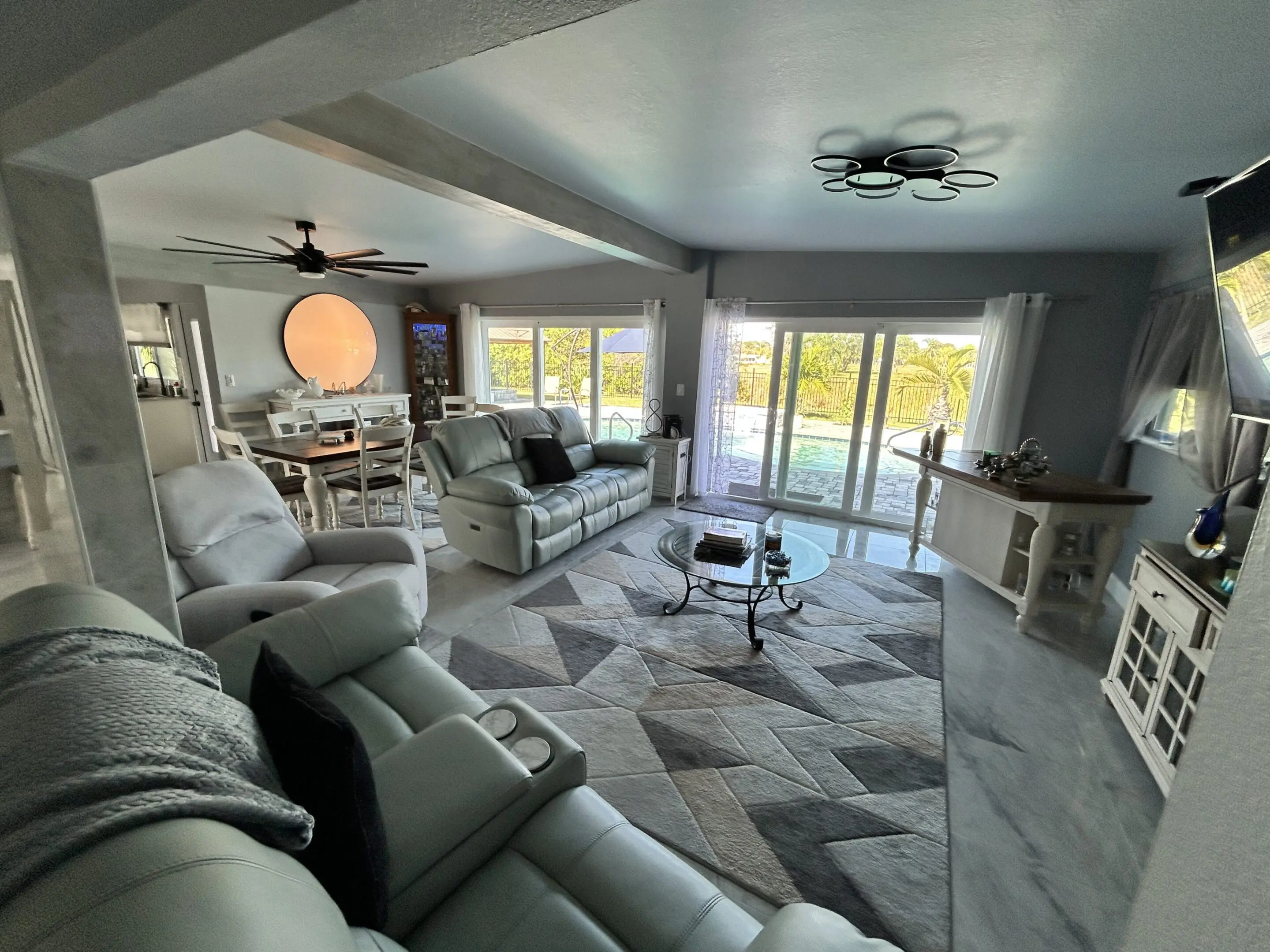 Spacious modern living room with large windows and comfortable seating.
