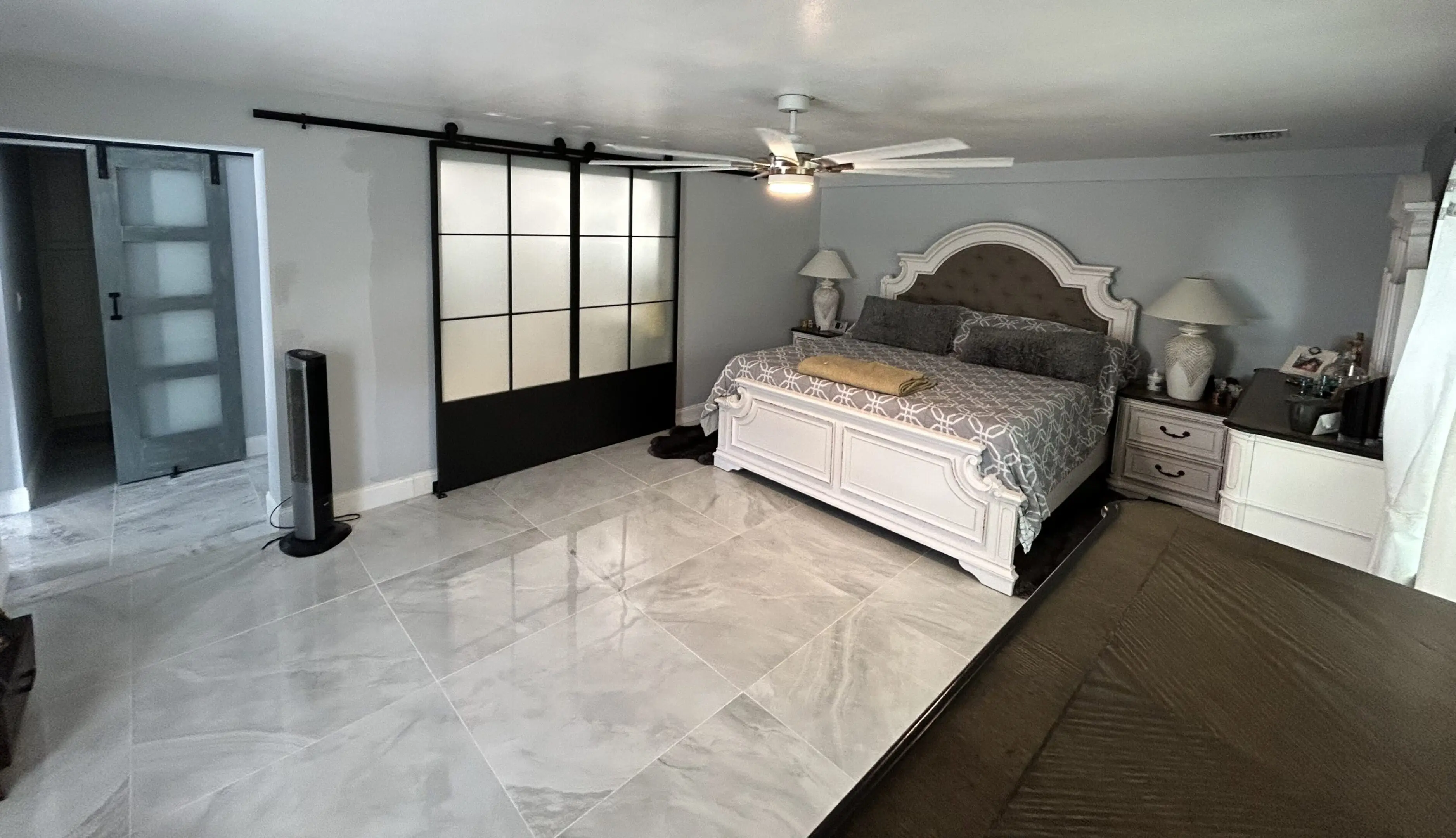Elegant bedroom with a white bed and large sliding wardrobe doors.