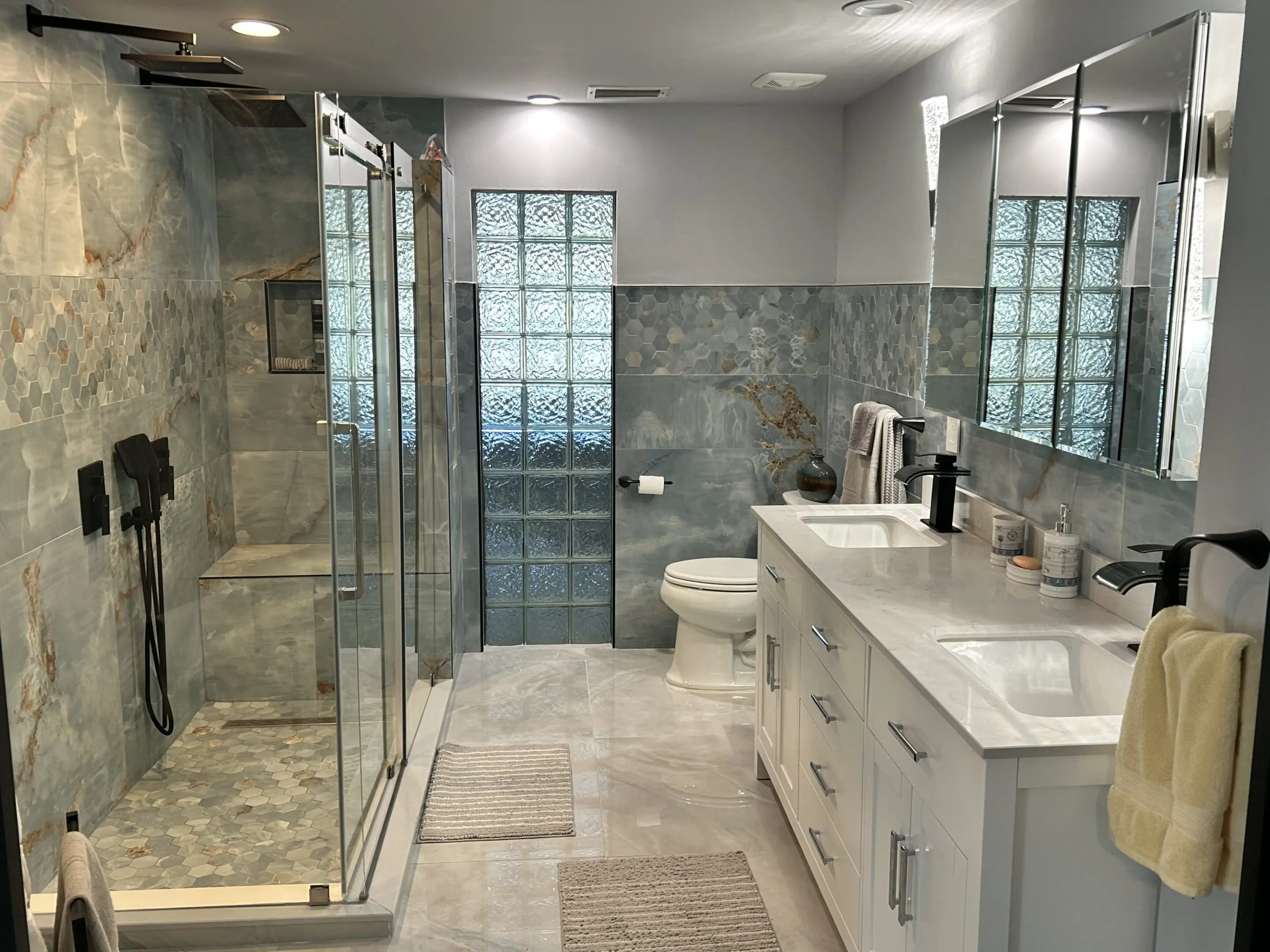 Modern bathroom with glass shower and sleek white vanity.