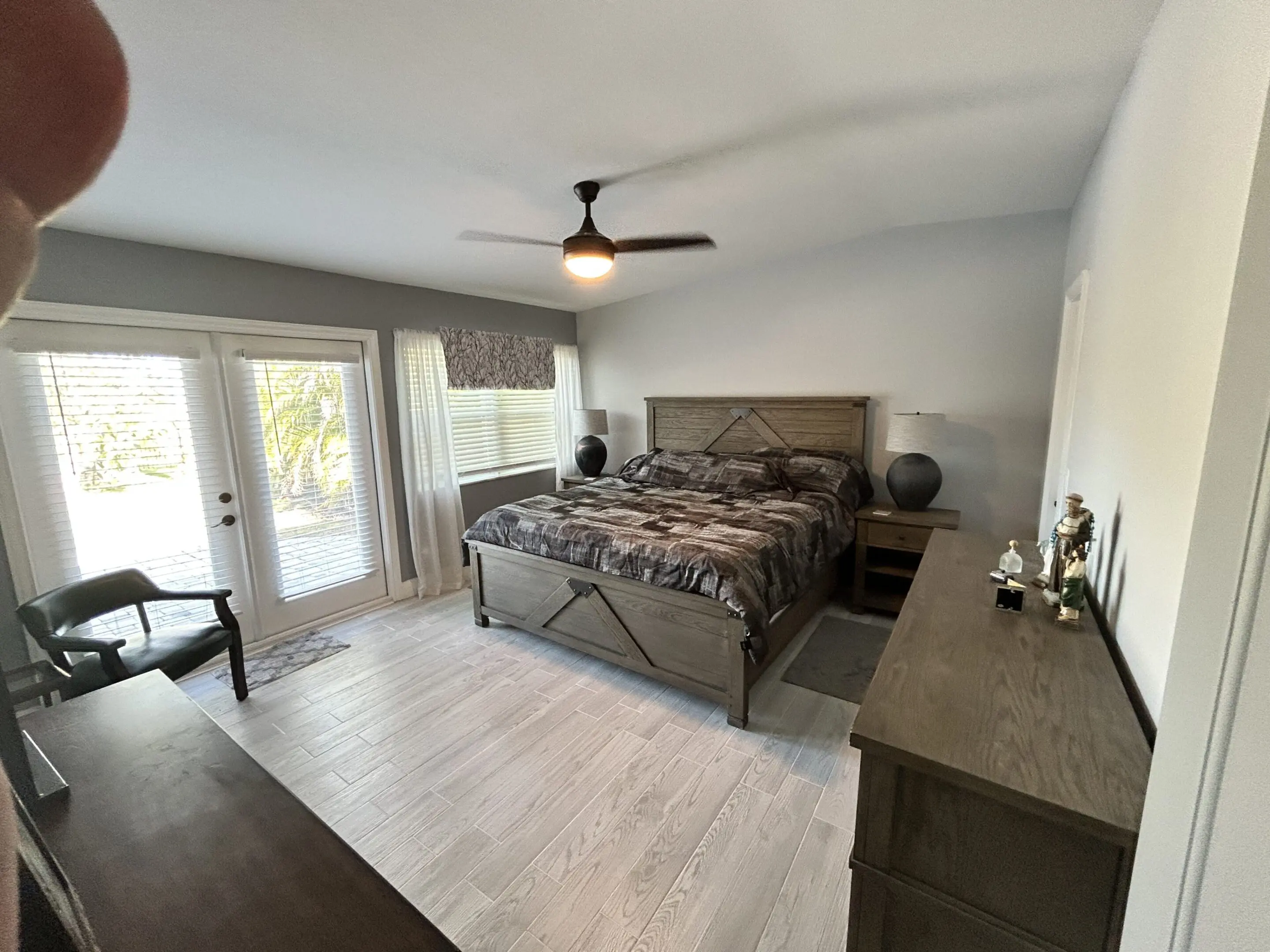 Spacious bedroom with a large bed and modern ceiling fan.
