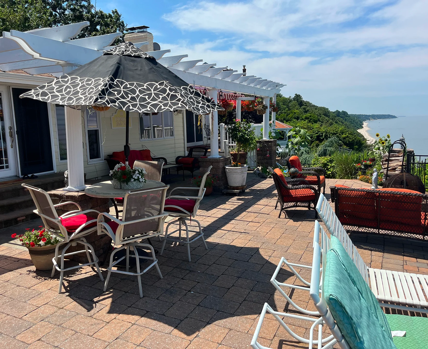 Cozy outdoor patio with seating and umbrella overlooking a scenic view.